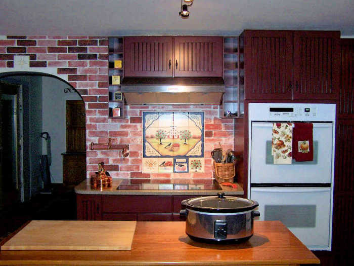Wide kitchen view of the installed American Folk Art Style tile mural designed by Julia Sweda.
