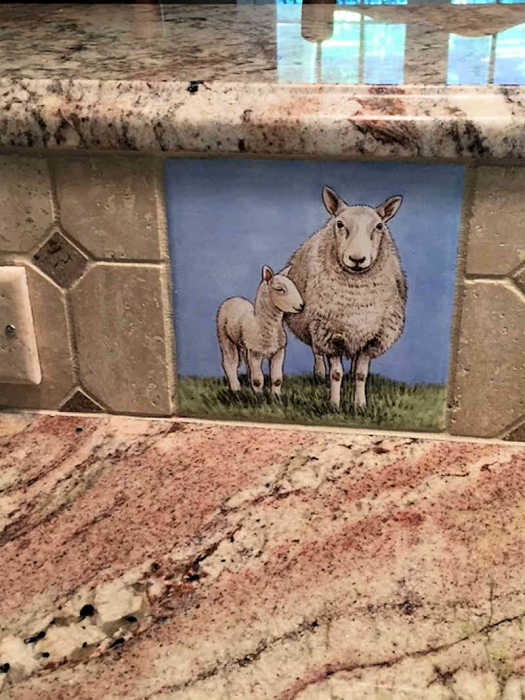 Annes Country Kitchen Animals, Ewe with single baby lamb portrait installed in riser of countertop. Artist Julia Sweda.