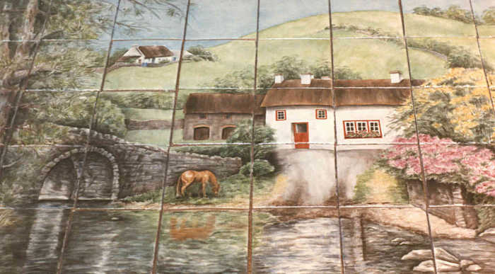Julias Irish Countryside Cottages View 1, all three cottages shown and lush green hillside in background, tile mural. Artist Julia Sweda.