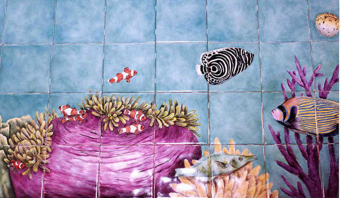 Clown fish swimming into the sea anemones closeup. Artist Julia Sweda.